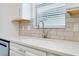 Kitchen featuring stainless steel sink, faucet and quartz countertops and light brick backsplash at 1565 Hyssop Loop, North Port, FL 34289