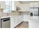 Bright kitchen with stainless steel appliances, light brick backsplash and white cabinets at 1565 Hyssop Loop, North Port, FL 34289