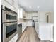 Bright open kitchen with stainless steel appliances and island with quartz countertops at 1565 Hyssop Loop, North Port, FL 34289