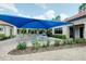 Outdoor patio area with table and chairs under a blue shade at 1565 Hyssop Loop, North Port, FL 34289