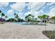 Beautiful community pool area surrounded by palm trees and brick pavers at 1565 Hyssop Loop, North Port, FL 34289