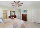 Comfortable bedroom with ceiling fan, en-suite, and a dresser with a TV at 1608 Saddlewood Cir, Port Charlotte, FL 33953