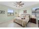 Bright bedroom with a ceiling fan, two windows, and warm decor at 1608 Saddlewood Cir, Port Charlotte, FL 33953
