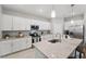 Contemporary kitchen boasts white cabinets, granite counters, stainless appliances, and pendant lighting at 1608 Saddlewood Cir, Port Charlotte, FL 33953