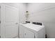 Convenient laundry room with modern appliances and a storage shelf, offering practicality at 1608 Saddlewood Cir, Port Charlotte, FL 33953