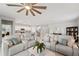 Open-concept living room with leather sofas, ceiling fan, and view into the modern kitchen at 1608 Saddlewood Cir, Port Charlotte, FL 33953