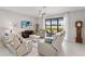 Comfortable living room with ample seating, a ceiling fan, and sliding glass doors to the outdoor area at 1608 Saddlewood Cir, Port Charlotte, FL 33953