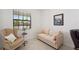 Comfortable seating area with accent chair, couch, and natural light; perfect for a reading nook at 1608 Saddlewood Cir, Port Charlotte, FL 33953