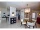 Bright and airy dining space featuring a modern chandelier and views of the kitchen and entry at 1711 Gondola Park Dr # 1711, Venice, FL 34292