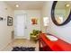 Bright foyer with neutral tiled floors, vibrant accent furniture, art and a decorative round mirror at 1711 Gondola Park Dr # 1711, Venice, FL 34292
