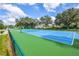 Outdoor tennis court with green and blue surface, surrounded by a green chain link fence at 1711 Gondola Park Dr # 1711, Venice, FL 34292