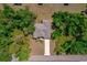 Aerial view of the home surrounded by mature trees with a long driveway at 172 Berthoud St, Port Charlotte, FL 33953