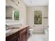 Bright bathroom features a granite countertop, wood cabinets, and a large window with lots of natural light at 172 Berthoud St, Port Charlotte, FL 33953