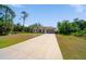 Attractive single-story home with a long driveway, attached garage, and lush landscaping at 172 Berthoud St, Port Charlotte, FL 33953