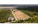 Aerial view displays an expansive property with a home, pond, ample land, and mature trees at 1727 E Manasota Beach Rd, Englewood, FL 34223