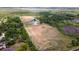 Aerial view of expansive property featuring a home, pond, surrounded by lush greenery and open space at 1727 E Manasota Beach Rd, Englewood, FL 34223