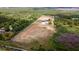 Aerial view showcases expansive property with a home, pond, lush greenery, and open land at 1727 E Manasota Beach Rd, Englewood, FL 34223