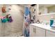 Well-lit bathroom with a glass enclosed shower, decorative curtains, and a white vanity at 1727 E Manasota Beach Rd, Englewood, FL 34223