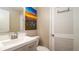 Bright bathroom featuring an art piece, a sink and a mirrored cabinet at 1727 E Manasota Beach Rd, Englewood, FL 34223