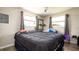 Bedroom with two windows providing natural light, comfortable bed and basic furnishings at 1727 E Manasota Beach Rd, Englewood, FL 34223