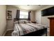 Cozy bedroom with wood floors, a patterned comforter and TV at 1727 E Manasota Beach Rd, Englewood, FL 34223