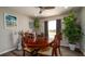 Cozy dining room features a wooden table, hanging plants, artwork, and natural light at 1727 E Manasota Beach Rd, Englewood, FL 34223