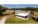 Charming home with a screened-in patio and a boat parked nearby, set on a grassy lot at 1727 E Manasota Beach Rd, Englewood, FL 34223