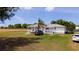 Exterior shot of a charming home featuring a well-kept lawn, a palm tree, and multiple parked vehicles at 1727 E Manasota Beach Rd, Englewood, FL 34223