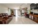 Bright living room with tile floors, leather sofa, and an adjacent office space at 1727 E Manasota Beach Rd, Englewood, FL 34223