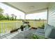 Cozy porch with seating, plants, and a view of the yard and trees at 1727 E Manasota Beach Rd, Englewood, FL 34223