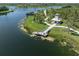 Picturesque aerial view of a tranquil lake with a wooden pier and a charming gazebo, offering serene waterfront scenery at 18002 Franklin Park Ct, Venice, FL 34293