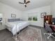 Bedroom features a metal frame bed, ceiling fan, gray wood-look floors, and a large window overlooking the yard at 18002 Franklin Park Ct, Venice, FL 34293