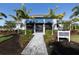Club Wysteria clubhouse exterior featuring a pathway and lush landscaping at 18002 Franklin Park Ct, Venice, FL 34293