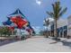 Attractive community area featuring colorful shade structures, seating, and a view of the surrounding shops and landscaping at 18002 Franklin Park Ct, Venice, FL 34293