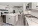 Stylish kitchen with white cabinetry, stainless steel appliances, a marble countertop island, and an open layout with the living area at 18002 Franklin Park Ct, Venice, FL 34293