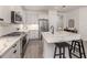 Bright kitchen features white cabinetry, stainless steel appliances, and quartz countertops with a breakfast bar at 18002 Franklin Park Ct, Venice, FL 34293