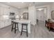 Bright kitchen features white cabinetry, stainless steel appliances, quartz countertops, and breakfast bar seating at 18002 Franklin Park Ct, Venice, FL 34293