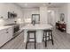 Modern kitchen featuring white cabinets, stainless steel appliances, a large island, and an open layout with the dining area at 18002 Franklin Park Ct, Venice, FL 34293