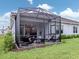 Screened lanai with outdoor seating and views of the green backyard at 18002 Franklin Park Ct, Venice, FL 34293