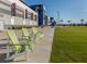 Outdoor seating area with green Adirondack chairs on a paved walkway, featuring well-maintained lawn and building at 18002 Franklin Park Ct, Venice, FL 34293