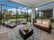 Inviting screened-in patio with comfortable seating, perfect for outdoor relaxation and entertaining with a view of the green backyard at 18002 Franklin Park Ct, Venice, FL 34293