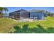 Well-manicured backyard with beautiful landscaping, lounging chairs, and a screened patio enclosure at 194 Sportsman Rd, Rotonda West, FL 33947