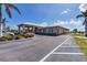 A community building showing the covered walkway, landscaping, parking, and lakeside view at 194 Sportsman Rd, Rotonda West, FL 33947