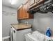 Convenient laundry room with front loading washer, countertop, and storage cabinets at 194 Sportsman Rd, Rotonda West, FL 33947