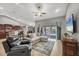 A spacious living room featuring a sectional sofa, television, and access to the outdoor pool area at 194 Sportsman Rd, Rotonda West, FL 33947