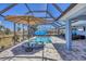 Relaxing pool and spa within an enclosed lanai, offering a private outdoor oasis with an umbrella at 194 Sportsman Rd, Rotonda West, FL 33947