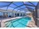 Gorgeous screened pool with a spa, outdoor dining, and lounging areas for optimal relaxation and entertainment at 194 Sportsman Rd, Rotonda West, FL 33947