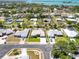 Stunning aerial view of a residential street with neatly landscaped homes, lush greenery, and a glimpse of the bay at 201 Bayside Ct, Nokomis, FL 34275