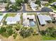 Scenic aerial view shows screened pool, solar panels, manicured lawns, and a tile roof at 201 Bayside Ct, Nokomis, FL 34275