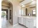 Bathroom with double sinks, arched doorway, and access to the outdoor pool area at 201 Bayside Ct, Nokomis, FL 34275